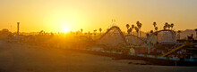 Sunset Over Santa Cruz Boardwalk With Amusement Rides And Palm Tree Silhouettes, California, USA