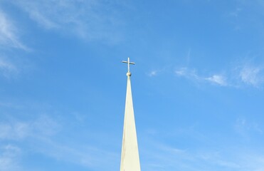 Humble design baptist christian religion church tower with cross  reaching into blue sky in Florida USA