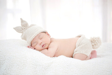 lovely newborn asian baby sleeping on furry cloth
