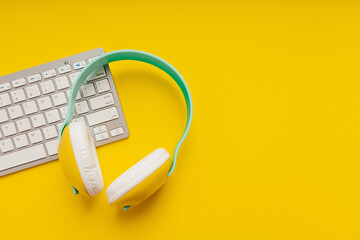 Headphones and keyboard on a yellow background