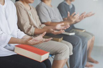 Asian Christian groups sitting within the Church Catholic prayed for blessings from God. A pale sun shone in a place of worship.Religious concepts.