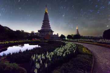 Wall Mural - star trails moving over a sacred temple at doi inthanon national park, chiang mai, thailand.