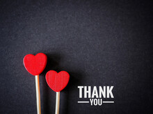 The Words Thank You Message And Two Red Heart On The Black Paper Background. Top Viwe, Flat Lay With Copy Space. Greeting Card..