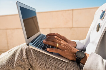 Close-up of man working in open air. Man in suit using laptop. Sitting at terrace or rooftops. Working, manager, technology concept