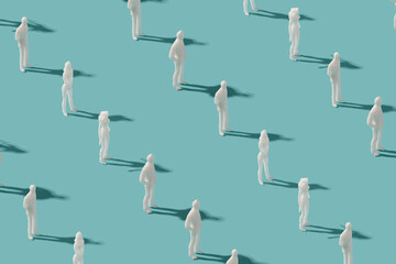  Plastic human figurines arranged on a pastel blue background. Futuristic society minimal pattern