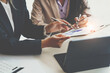 © crizzystudio - crop shot of Asian business professionals working together and discussing work sitting at a conference table in the office. Financial analysts analyze business financial reports