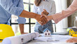 © crizzystudio - Architect and engineer construction workers shaking hands after successful collaboration. working site, Construction, contract between two companies structure concept