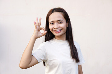 Asian woman smiling happily Raise your hand as a sign of ok.