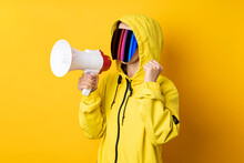 Young Woman In Cyberpunk Glasses With A Megaphone In A Yellow Jacket On A Yellow Background.