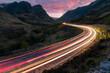 Car light trails on winding road through the highlands near Glencoe in Scotland at dusk