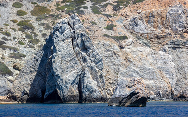 Wall Mural - Aegean Sea. Rocky coast, cliff and cave, rippled ocean. Cyclades Greece. Seascape near Nios island