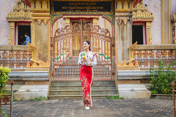 Beautiful Asian girl at big Buddhist temple dressed in traditional costume