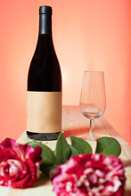 Abriendo Botella De Vino Al Atardecer Con Fondo Colorido Y Rosas Rojas Y Blancas