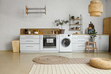 Stylish interior of kitchen with modern washing machine