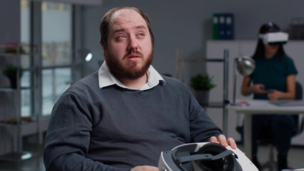 Portrait of overweight employee with tired eyes after using vr headset 