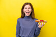 Young English woman holding sashimi isolated on yellow background with surprise facial expression