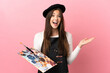 © luismolinero - Young artist girl holding a palette over isolated pink background with shocked facial expression
