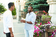 © etonastenka - A black businessman is talking in an informal setting with a business partner on a city street