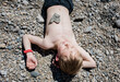 © Cavan Images - boy laying on stones witha heart shaped stone on his heart