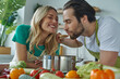 © gstockstudio - Cheerful young couple tasting something from a pan at the domestic kitchen