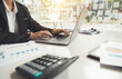 © PaeGAG - Woman investment consultant analyzing company annual financial report balance sheet statement working with documents graphs. Stock market. financial and investment concept.