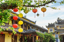 Yellow And Red Silk Lanterns On Green Branches Of Tree