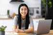 © kucherav - Portrait of happy asian female student or freelancer looking at camera, studying remotely using laptop or working from home, e-learning, home office concept