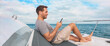 © Maridav - Phone using on cruise ship. Man luxury travel texting with data on yacht boat relaxing on deck banner panoramic. Caribbean vacation