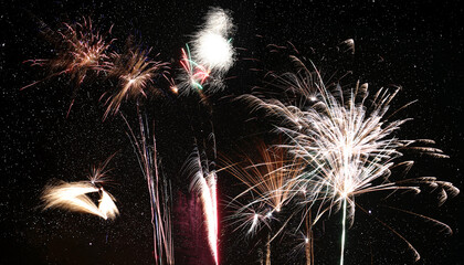 Wall Mural - row of different fireworks in front of starry sky