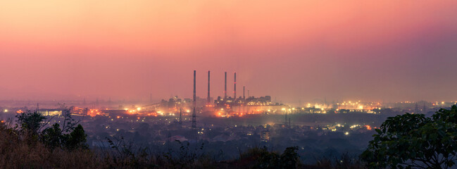 Panoramic industrial landscape. silhouette of an industry zone with factories and plants during sunset or sunrise