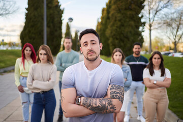 Man looking serious at the camera while standing in front of a group of people. Team and leadership concept.