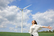 © Antonioguillem - Happy woman outstretching arms in a wind farm