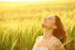 © Antonioguillem - Woman breathing fresh air sitting in a wheat field