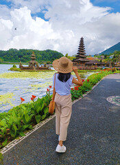 Woman traveler at Pura Ulun Danu Beratan Bedugul temple on a lake in Bali, Indonesia