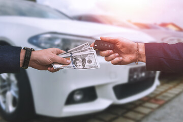 Wall Mural - man hands over a large sum of dollars to another who in return passes the keys to a car bought