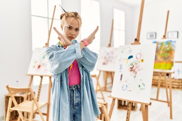 Poster - Young caucasian girl at art studio rejection expression crossing arms doing negative sign, angry face