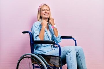 Sticker - Beautiful blonde woman sitting on wheelchair excited for success with arms raised and eyes closed celebrating victory smiling. winner concept.