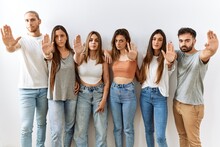 Group Of Young Friends Standing Together Over Isolated Background Doing Stop Sing With Palm Of The Hand. Warning Expression With Negative And Serious Gesture On The Face.