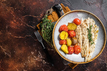 Roasted Pollock Fish Fillet In Plate With Garnish Tomato And Potato. Dark Background. Top View. Copy Space