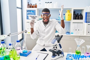 Poster - African american man working on cruelty free laboratory celebrating victory with happy smile and winner expression with raised hands