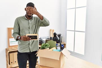 Sticker - Young african american businessman unboxing box at the office covering eyes with hand, looking serious and sad. sightless, hiding and rejection concept