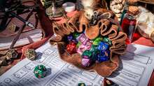 A Leather Dice Bag Filled With Dice On A Character Sheet