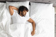 © Prostock-studio - Top view of indian guy sleeping alone in bed