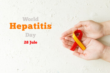 World hepatitis day. Adult hands holding red yellow ribbon on white background. Awareness of prevention and treatment viral hepatitis. Liver cancer. World cancer day. banner