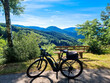 Electric Bicycle  stands on a viewing platform in the beautiful countryside. Panoramic viewpoint with green vegetation, mountains and blue sky. Black Forest, Ortenau, Germany.