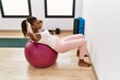 © Krakenimages.com - Young african american woman training abs exersice at sport center
