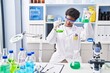 © Krakenimages.com - African american woman wearing scientist uniform measuring liquid at laboratory