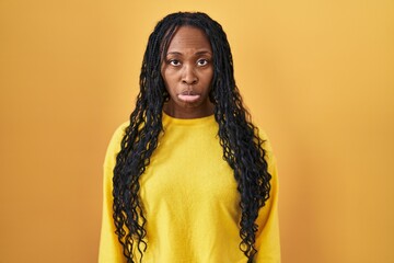 Wall Mural - African woman standing over yellow background depressed and worry for distress, crying angry and afraid. sad expression.