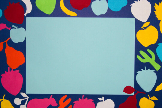 colorful fruit on a dark blue background with blank pastel blue paper as copy space, creative summer design, trendy colors, creative concept