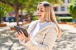 © Krakenimages.com - Young woman smiling confident watching video on touchpad at park